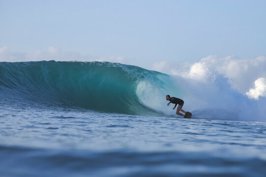 Surfer Crouching Inside Turquoise Ocean Barrel
