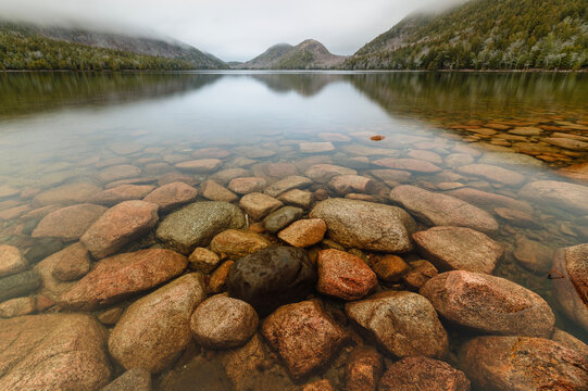 Clear waters of Jordan Pond with boulders and mountains, Acadia