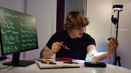 Young engineer calibrates glowing arm implant while coding neural systems in futuristic home lab with digital equations tools and intense focused experimentation for brea - Powered by Adobe