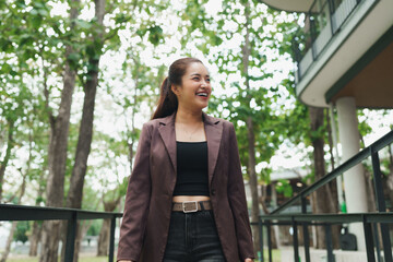 Obraz premium Young asian woman smiling, feeling happy outdoors