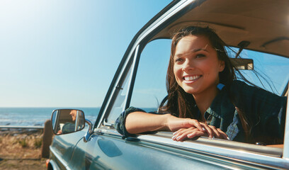 Road trip, girl and happy in car at beach for travel adventure, journey pause and scenic view. Space, driver and smile in transportation for weekend getaway, exploring break or window with fresh air