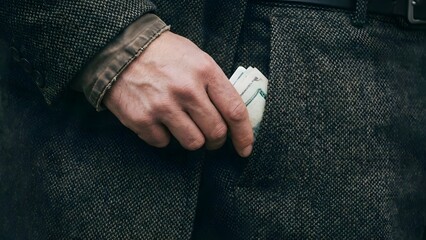 Man holding cash in pocket closeup.