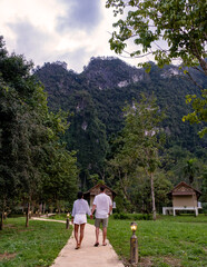 Couple walking hand in hand through lush trails of Khao Sok national park, Thailand