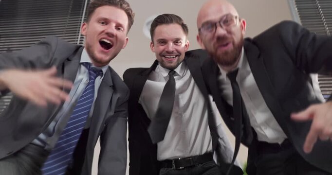 Businessmen in office celebrate success with fun dance. Happy men enjoy a lively office party celebration, colleagues bond and team morale rises. Strong teamwork and business success concept.