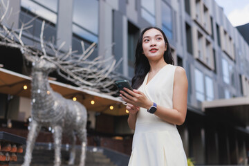 Young asian woman using smartphone exploring urban environment