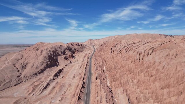 San Pedro de Atacama, Chile: Aerial footage of empty road between rock formation in San Pedro de Atacama, Chile on sunny day. Taken with forward motion 