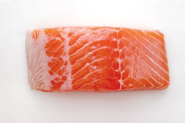 A piece of fresh salmon. The vivid pink raw salmon is placed on a white background.