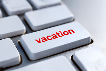 Close up of a red word vacation on keyboard button of a white computer