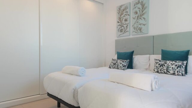 Bright twin bedroom with soft headboard and artwork