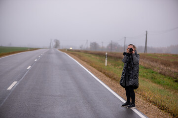 Middle Aged Woman Photographing Roadside in Latvia