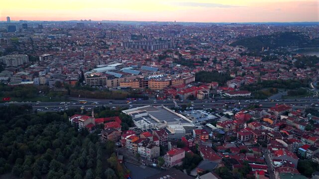 Istanbul Turkey T&uuml;rkiye aerial drone traffic cars bridge Bosphorus Strait ferry boats sunset golden hour pink sky cityscape buildings panoramic landscape skyscrapers mosque forward pan up motion