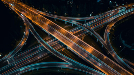 Aerial View of a Complex Highway Interchange at Night with Light Trails from Moving Cars traffic