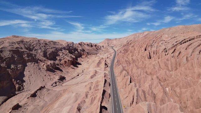 San Pedro de Atacama, Chile: Aerial footage of car driving on the road between rock formation in San Pedro de Atacama, Chile on sunny day. Taken with forward motion 