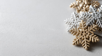 Glittery metallic snowflakes cluster in corner against neutral concrete festive backdrop.