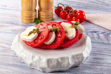 Italian Caprese salad with tomato, mozarella and pesto