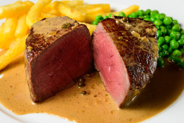 Filet Mignon Beef Steak with Green Peppercorn Sauce with French Fries and Peas called Steak au Poivre Vert in French