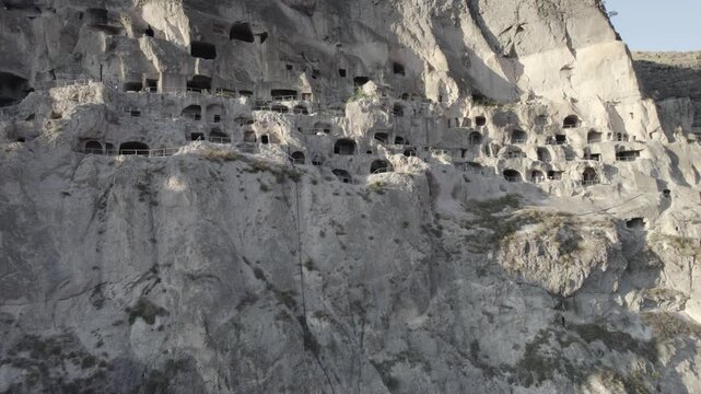 Aerial view of Vardzia, the ancient cave monastery town carved into rock in Georgia, captured at sunset
