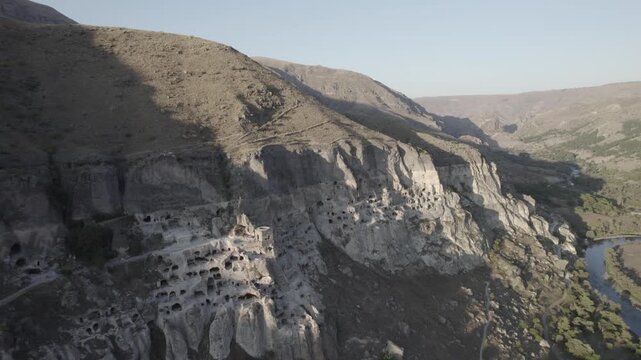 Aerial view of Vardzia, the ancient cave monastery town carved into rock in Georgia, captured at sunset