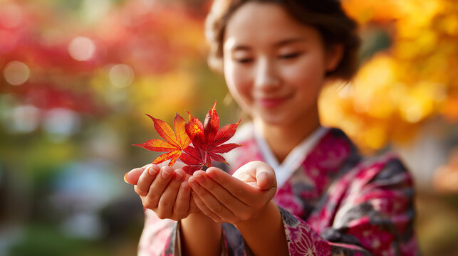 Faceless woman in autumn kimono holding red maple momiji leaf, fall season appreciation, defocused colorful foliage background, with copy space