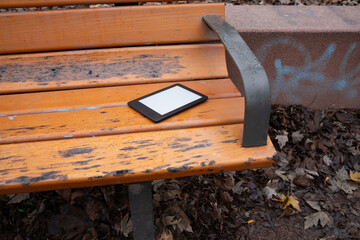 Ebook on a light wooden park bench