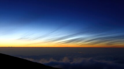 Fototapeta premium wholeness. Golden sunrise over a calm horizon, first light on clouds, serene landscape with deep blue sky. travel magazines, destination branding, designed for outdoor magazines and nature guides.