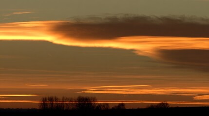 Fototapeta premium wholeness. Golden sunrise over a calm horizon, first light on clouds, serene landscape with deep blue sky. travel magazines, destination branding, designed for outdoor magazines and nature guides.
