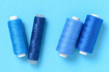 Blue thread spools background with copy space for text close-up flat lay top view