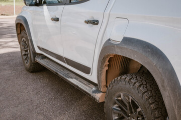 A white SUV truck car with mud on the wheel after driving through the wilderness of Flinders Ranges during a road trip in the outback of Australia.