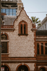 Vertical image of the exterior of a historical building made with bricks outdoor at daytime during springtime season in Adelaide city in Australia.