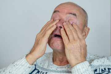 man 60-65 years old, senior crying, suffering, fatigue syndrome eye Asthenopia, eye pain symptoms, including strain, allergies, severe eye conditions, corneal ulcers, glaucoma or acute angle-closure