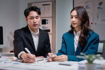 Asian business colleagues collaborating on financial reports in office
