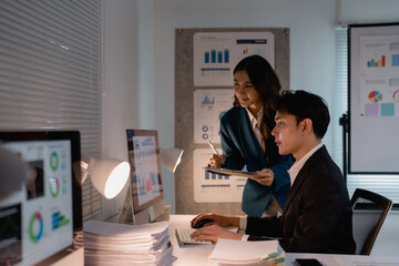 Business colleagues collaborating on data analysis working late