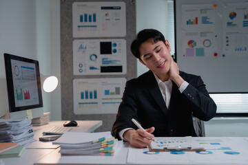 Businessman feeling neck pain working late at office