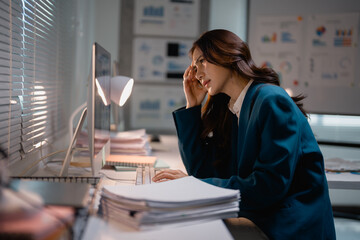 Tired businesswoman experiencing stress working late night