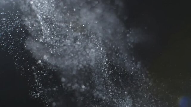Abstract cinematic slow motion footage of water particles and mist drifting in dark environment
