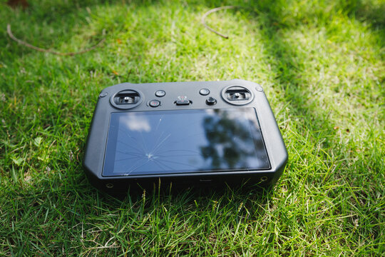 Broken drone remote controller on the green grass