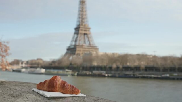 Paris France Handheld Shot of Croissant with Blurred Eiffel Tower