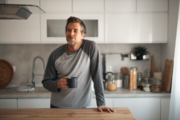 Relaxed Man With Coffee Mug In Modern Kitchen Setting For A Quiet Morning