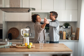 Couple Dancing Together in a Modern Kitchen, Enjoying a Warm Home Moment
