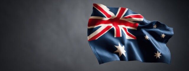 Waving Australian flag against a dark background in a studio setting during daytime
