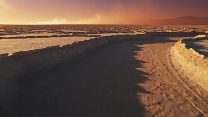 Cracked salt crust on salt flat at sunset