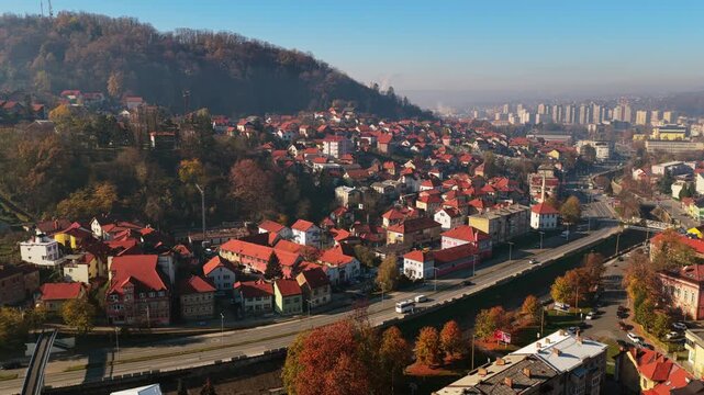 Aerial drone view of Tuzla's hillside neighborhoods with traditional homes and red rooftops, blending into the broader city skyline