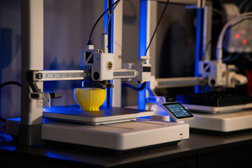 Close-up of 3D printer nozzle printing a yellow lattice sphere object. Additive manufacturing process in a high-tech laboratory.