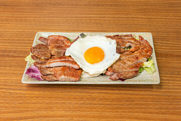 Cantonese-style fried pork with black bean and garlic sauce, accompanied by thickly sliced ​​green bell peppers and onions on a bed of noodles