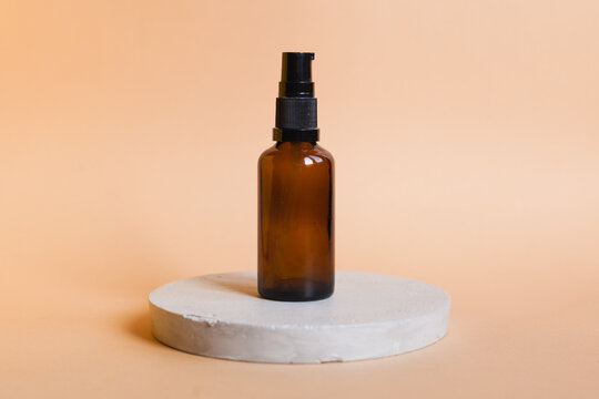 Different serum cosmetic bottles, white and dark brown dropper bottle container and packaging skincare product. studio pastel light background.