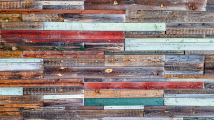 A seamless pattern of aged, multicolored wooden planks arranged horizontally. The weathered, rustic surface is perfect for backdrops, designs, or vintage decor concepts.