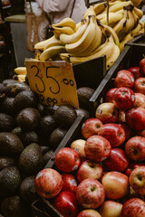 Vertical image of healthy fruit ripe avocados, red apples and bananas ready to sell and eat inside the building of the Central Market in Adelaide Australia.