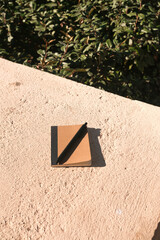 Notebook mockup with black pen on rock surface at the park. Creative flat lay concept for template mockup.