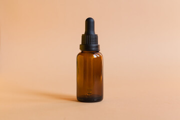 Naklejka premium Different serum cosmetic bottles, white and dark brown dropper bottle container and packaging skincare product. studio pastel light background.
