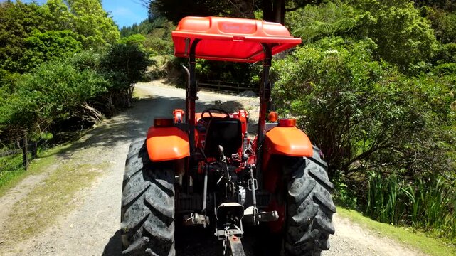 Orange tractor on rural forest road